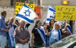 Des Israëliens brandissent des drapeaux et des pancartes en hébreu "Le peuple n'abandonne pas un soldat" devant l'entrée du tribunal militaire à Tel Aviv où se déroule le procès d'Elor Azaria le 9 mai 2016