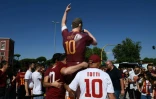 Des supporters de l'AS Rome posent à côté d'une statue de Francesco Totti à quelques heures de son dernier match sous le maillot de la Roma, le 28 mai 2017 au Stade Olympique