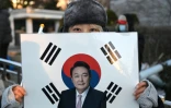 Une supportrice tient un portrait de l'ancien président sud-coréen destitué, Yoon Suk Yeol, devant le tribunal du district central de Séoul où doit se tenir son dernier procès pénal pour insurrection, le 13 janvier 2026