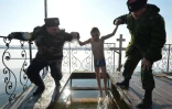 Des cosaques aident un garçon à se baigner dans des eaux glaciales d'un lac pour célébrer la fête orthodoxe de l'Epiphanie près du village de Pokrovka, à 15 kilomètres de Bichkek en Kirghizie