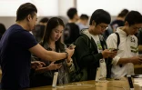 Des personnes regardent l'iPhone X en vente dans une boutique Apple, le 3 novembre 2017 Ă Hong Kong