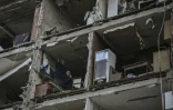 Un homme dans un appartement d'un immeuble détruit par un bombardement russe, le 25 mars 2022 à Kharkiv, en Ukraine