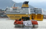 Des membres du Syndicat des travailleurs corses (STC) à bord d'une chaloupe de sauvetage sur laquelle a été déployé une banderole "Gloire à Yvan (Colonna)", pour empêcher l'accostage d'un ferry à Ajaccio, le 4 mars 2022