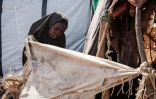 Salado Adan Mohamed, une mère de famille de 26 ans, arrange son abri de fortune dans le camp de déplacés de Muuri à Baidoa (Somalie), le 13 février 2022