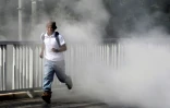 Un homme fuit les fumées de pneus en feu à Sebaco, à une centaine de km de Managua, le 11 juin 2018