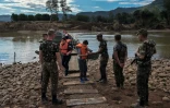 Des militaires récupèrent les gilets de sauvetage utilisés par des personnes qui ont traversé la rivière Forqueta sur une passerelle flottante, le 21 mai 2024, à Lajeado, au Brésil