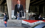 Un Syrien passe devant un portrait géant du président Assad dans une rue de Damas, le 26 février 2016