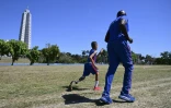 Juan José Guilarte, 10 ans, court avec son entraîneur, Albert Luis Campbell, pendant une session de pentathlon à La Havane, le 16 avril 2026 à Cuba
