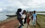 Des réfugiés Rohingyas qui portent un parent âgé arrivent de Birmanie après avoir traversé la rivière Naf de la ville de Teknaf au Bangladesh le 12 septembre 2017