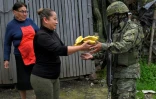 Une femme offre des bananes Ă un militaire dans le quartier de Lucha de los Pobres, dans le sud de Quito, le 12 janvier 2024