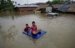 Des habitants de la région Mawlamyine, dans le sud de la Birmanie, utilisent un radeau improvisé après les inondations qui ont sinistré le secteur, le 18 juin 2018