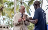 Le roi Charles III s'apprête à placer du corail dans un bloc de béton qui sera jeté à la mer, dans le cadre du projet de restauration du corail dans la zone de conservation de Kuruwitu, le 2 novembre 2023 à Kilifi, au Kenya