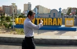 Un Iranien marche dans le centre de Téhéran le 23 juin 2025

