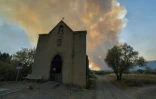 Les fumées d'un incendie visibles derrière une église à Tournissan, dans l'Aude, le 5 août 2025