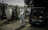 Un employé des pompes funèbres à côté de cercueils de victimes du Covid-19 dans un cimetière de Lisbonne, au Portugal, le 18 février 2021