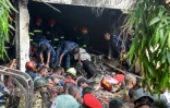 Des secouristes bangladais sur les lieux du crash d'un avion militaire, tombé sur une école de Dacca, le 21 juillet 2025