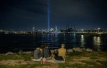 Des personnes regardent une installation lumineuse en hommage aux victimes du 11-Septembre à New York, le 10 septembre 2022