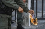 Un soldat brûle un exemplaire du texte de loi d'amnistie aux militaires soutenant le président autoproclamé Juan Guaido, devant l'entrée du quartier général de l'armée à Caracas, le 27 janvier 2019