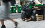 Une femme marche près d'une pile d'ordures à Paris, le 8 juin 2016