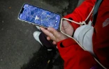Anastassiia Jmoutska suit les déplacements de son fils Orest sur une carte affichée sur son smartphone, le 13 octobre 2026 à Kiev, en Ukraine