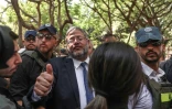 Le ministre israélien de la Sécurité nationale, Itamar Ben Gvir (C), flanqué de gardes du corps, arrive sur les lieux d'une attaque au couteau à Holon, dans la banlieue sud de Tel Aviv, le 4 août 2024