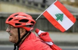 Un cycliste libanais chevauche avec un drapeau national à travers la région de Dbayeh au nord de Beyrouth, en soutien aux protestations au Liban contre l'élite dirigeante et les conditions économiques désastreuses, le 23 octobre 2019