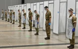 Des soldats observent deux minutes de silence pour le jour de l'Armistice, le 11 novembre 2020 dans un centre de tests rapides du Covid-19 à Liverpool (Angleterre)