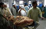 Une personne blessée pendant le séisme est accompagnée par ses proches à l'hôpital de Peshawar, le 26 octobre 2015 au Pakistan