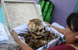 Une femme se prépare à nettoyer les restes d'un proche avant les célébrations du Jour des morts au cimetière de Pomuch, dans l'État de Campeche, au Mexique, le 18 octobre 2025