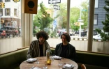 Siavash Karampour (à gauche) et Sasan Oskouei (à droite) posent avec une bouteille de leur eau-de-vie traditionnelle iranienne, l'aragh sagi, dans un restaurant de Brooklyn à New York, le 28 avril 2026
