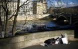 Un homme sans-abri dort le long d'un trottoir surplombant la Seine, à Paris, le 28 décembre 2017