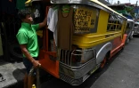 Un chauffeur de jeepney suspend ses vêtements à l'extérieur du véhicule transformé en logement, le 12 août 2020 à Manille, aux Philippines