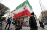 Un drapeau iranien géant déployé sur la façade d'un immeuble à Téhéran, le 15 mars 2026