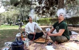 Deux Iraniens fument la chicha assis dans le parc Mellat de Téhéran, le 2 avril 2026, lors de la "Journée de la nature" qui marque la fin des festivités de Norouz, le Nouvel an persan