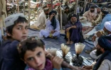 Des hommes rassemblés autour de sacs contenant de l'héroïne et du haschisch en vérifient la qualité, sur un marché à l'extérieur de Kandahar, en Afghanistan, le 24 septembre 2021