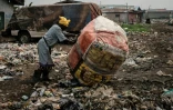Une femme pousse un sac contenant des bouteilles de plastique recyclées, le 12 février 2019 dans un quartier de Lagos, au Nigeria