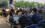 Des ingénieurs du son contrôlent les  vestes tactiles portées par des spectateurs lors d'un concert en extérieur au Lincoln Center de New York, le 22 juillet 2023