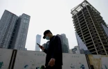Un passant consulte son smartphone dans une rue de Pékin, le 9 mai 2022