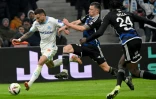 Le milieu de l'OM Jonathan Clauss (g) à la lutte avec le défenseur strasbourgeois Frédéric Guilbert (c), le 12 janvier 2024 au Stade Vélodrome