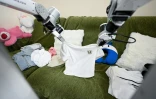 Un robot de ménage X Square plie des vêtements au domicile d'une cliente, le 21 mai 2026 à Pékin, en Chine