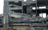 Un Palestinien se fraye un chemin dans les décombres d'un bâtiment détruit par une frappe israélienne dans le camp de réfugiés de Bureij, dans le centre de la bande de Gaza, le 10 juillet 2025