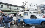 Un homme charge des cartons d'huile de cuisine sur le toit d'un taxi dans le quartier historique de Merkato, à Addis-Abeba, en Éthiopie, le 14 septembre 2024