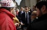 Le président Emmanuel Macron (c) rencontre des habitants sur un marché de Dole, le 27 avril 2023 dans le Jura