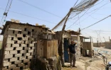 Un électricien fait une pause dans son travail sur un générateur, à Diwaniyah, dans le sud de l'Irak, le 10 août 2025