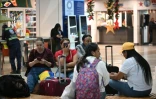 Des voyageurs attendent un vol à l'aéroport international Simon Bolivar de Maiquetia, le 27 novembre 2025 au Venezuela