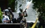 Un soldat tire une grenade de gaz lacrymogène pour tenter de disperser les manifestants, devant les bureaux du Premier ministre à Colombo le 13 juillet 2022