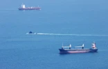 Un sous-marin de la marine israélienne (au centre) passe entre deux navires au large de la ville de Haïfa, dans le nord d'Israël, le 12 août 2024