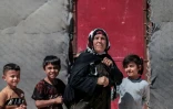 Une femme kurde syrienne déplacée, originaire de la ville de Ras al-Aïn, avec des enfants dans le camp de déplacés d'al-Talaeh, à Hassaké, dans le nord-est de la Syrie, le 23 juillet 2026