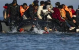 Des migrants tentent d'embarquer sur un bateau de passeurs afin de traverser la Manche au large de Gravelines (nord de la France) le 27 septembre 2025