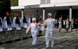 L'Italienne Stefania Belmondo et le Grec Petros Gaidatzis portent ensemble la flamme olympique à la sortie du musée du site antique d'Olympie, en Grèce, le 26 novembre 2025
